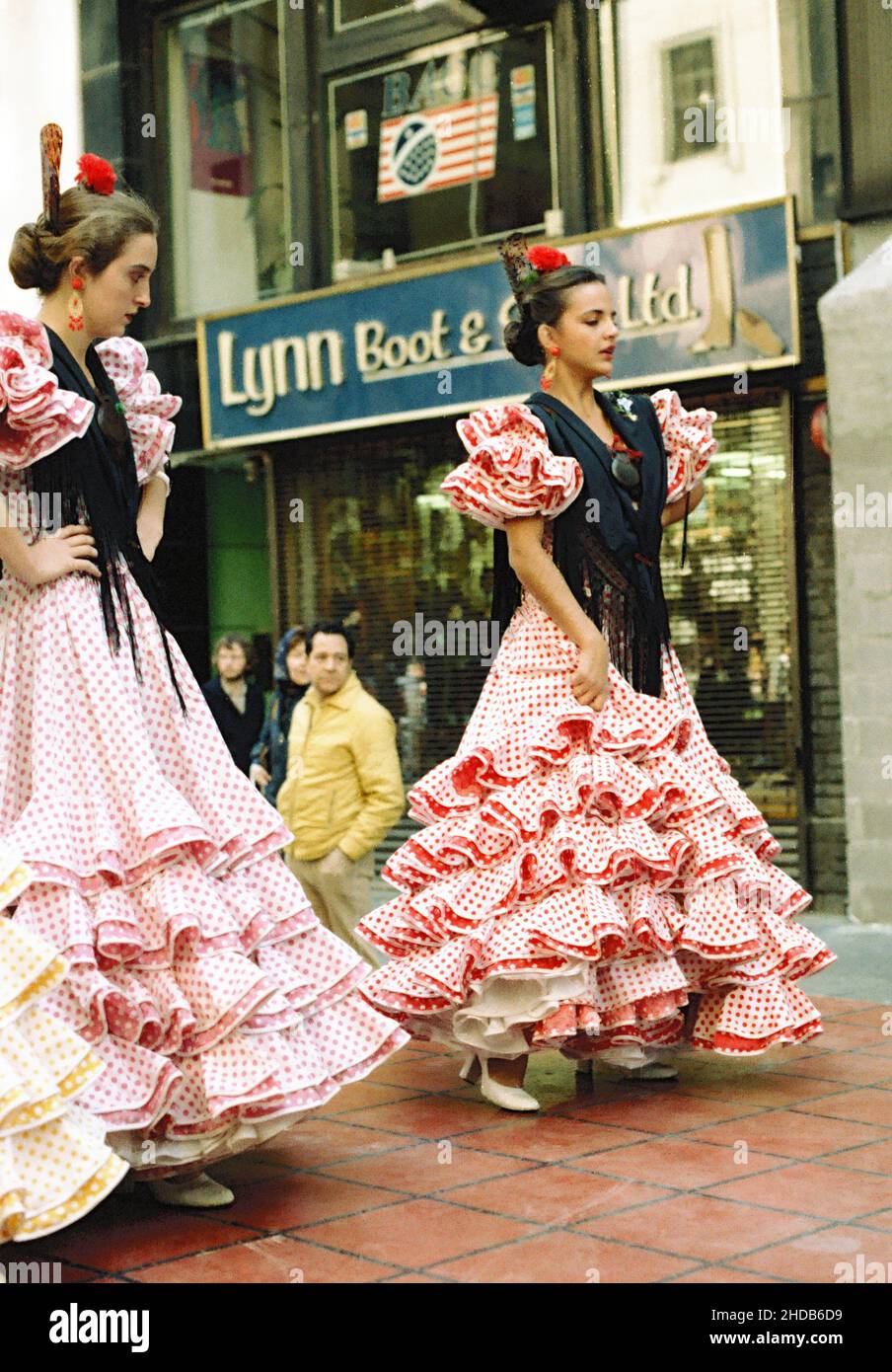 Junge Frauen tanzen in traditionellen Kleidern auf der Straße bei der Columbus Day Parade in den frühen achtziger Jahren in New York, USA Stockfoto