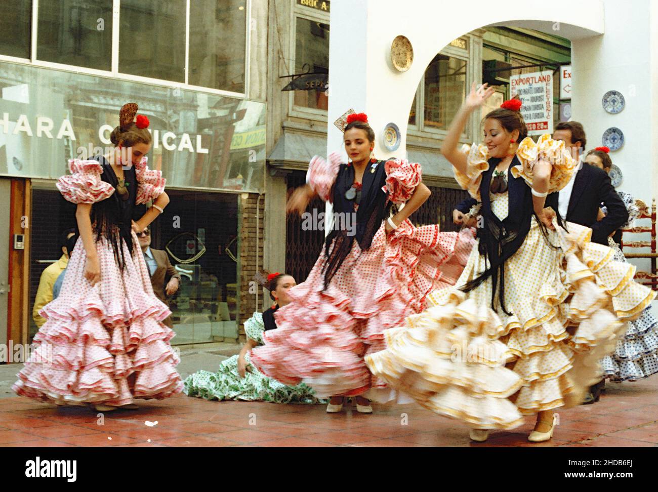 Junge Frauen tanzen in traditionellen Kleidern auf der Straße bei der Columbus Day Parade in den frühen achtziger Jahren in New York, USA Stockfoto