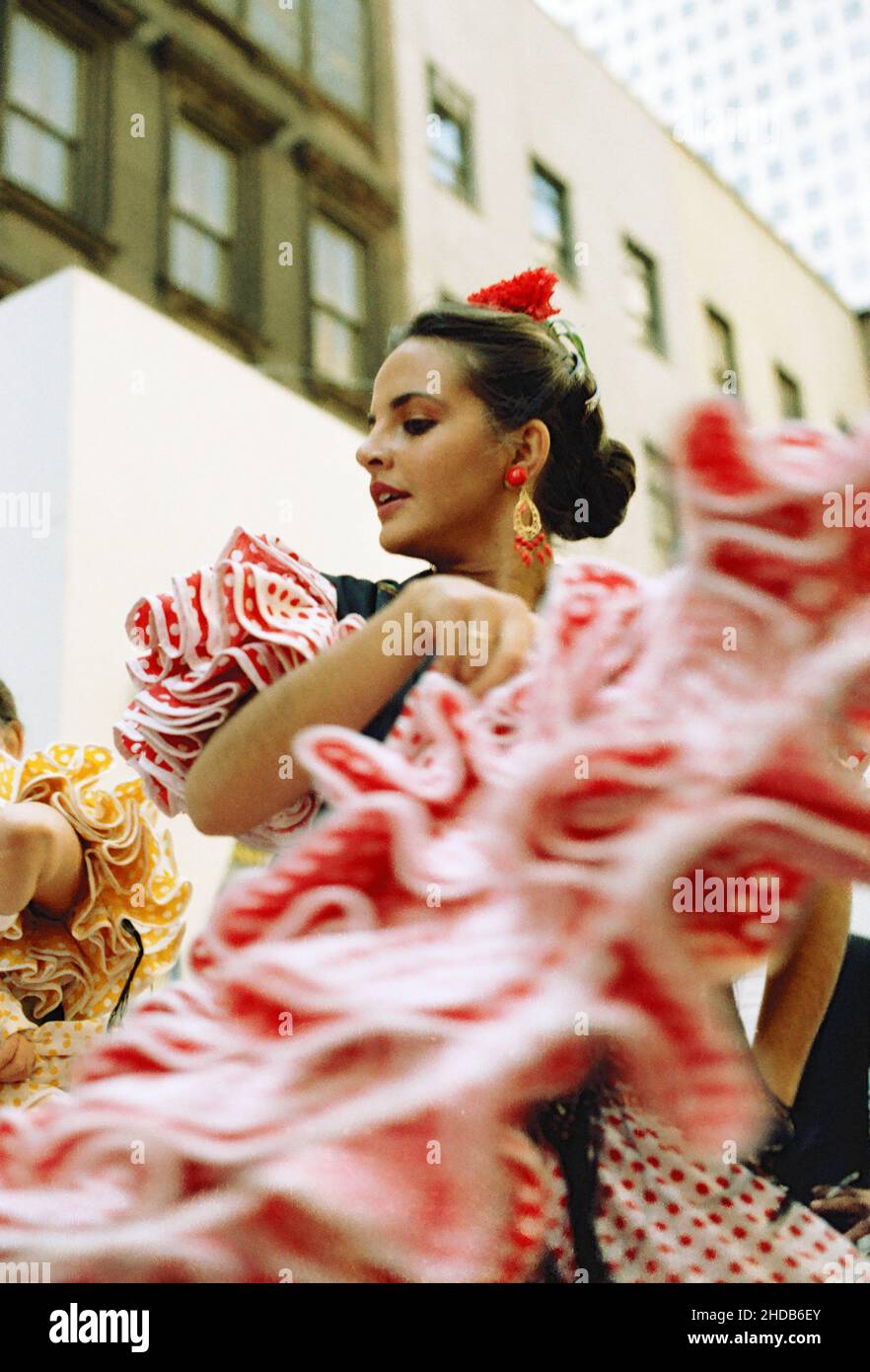 Eine junge Frau in traditionellem Kleid tanzt auf der Straße bei der Columbus Day Parade in den frühen achtziger Jahren in New York, USA Stockfoto