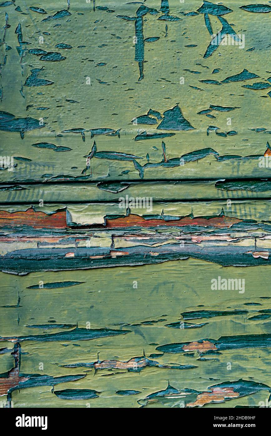 Blick von oben auf abblätternde verwitterte Beschichtungen von zwei verschiedenen Grüns auf Holz. Vertikal. Stockfoto