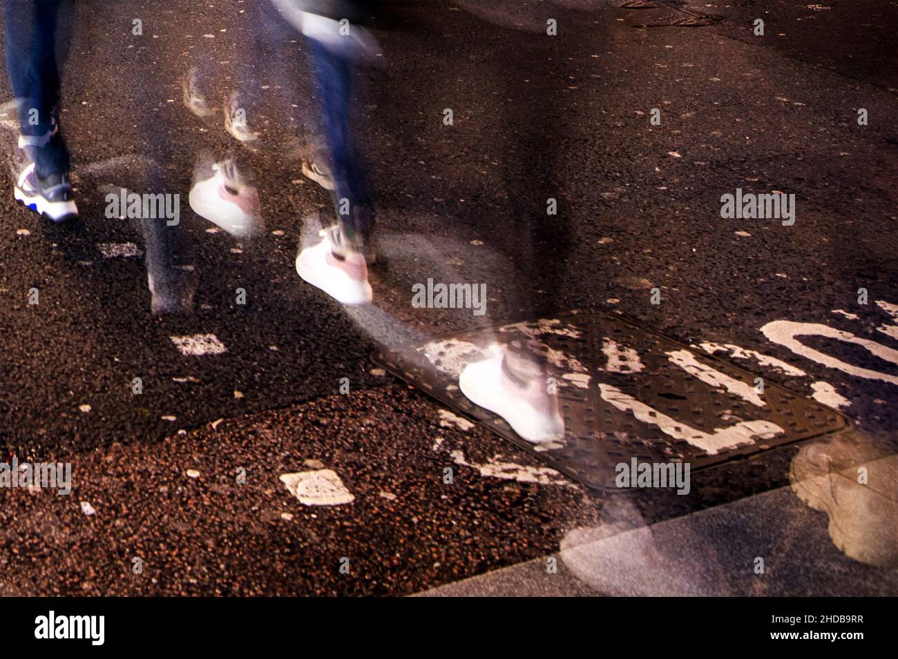 Oxford Street in der Abenddämmerung; eine geschäftige Einkaufsstraße im Zentrum von London, lange Belichtung verschwimmt Beine und Füße von Spaziergängern Stockfoto