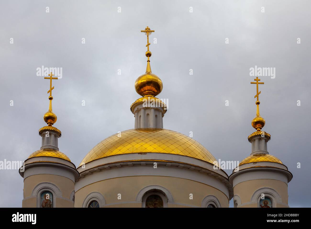 Die vergoldeten Kuppeln der orthodoxen Kirche gegen den dunklen Himmel. Stockfoto