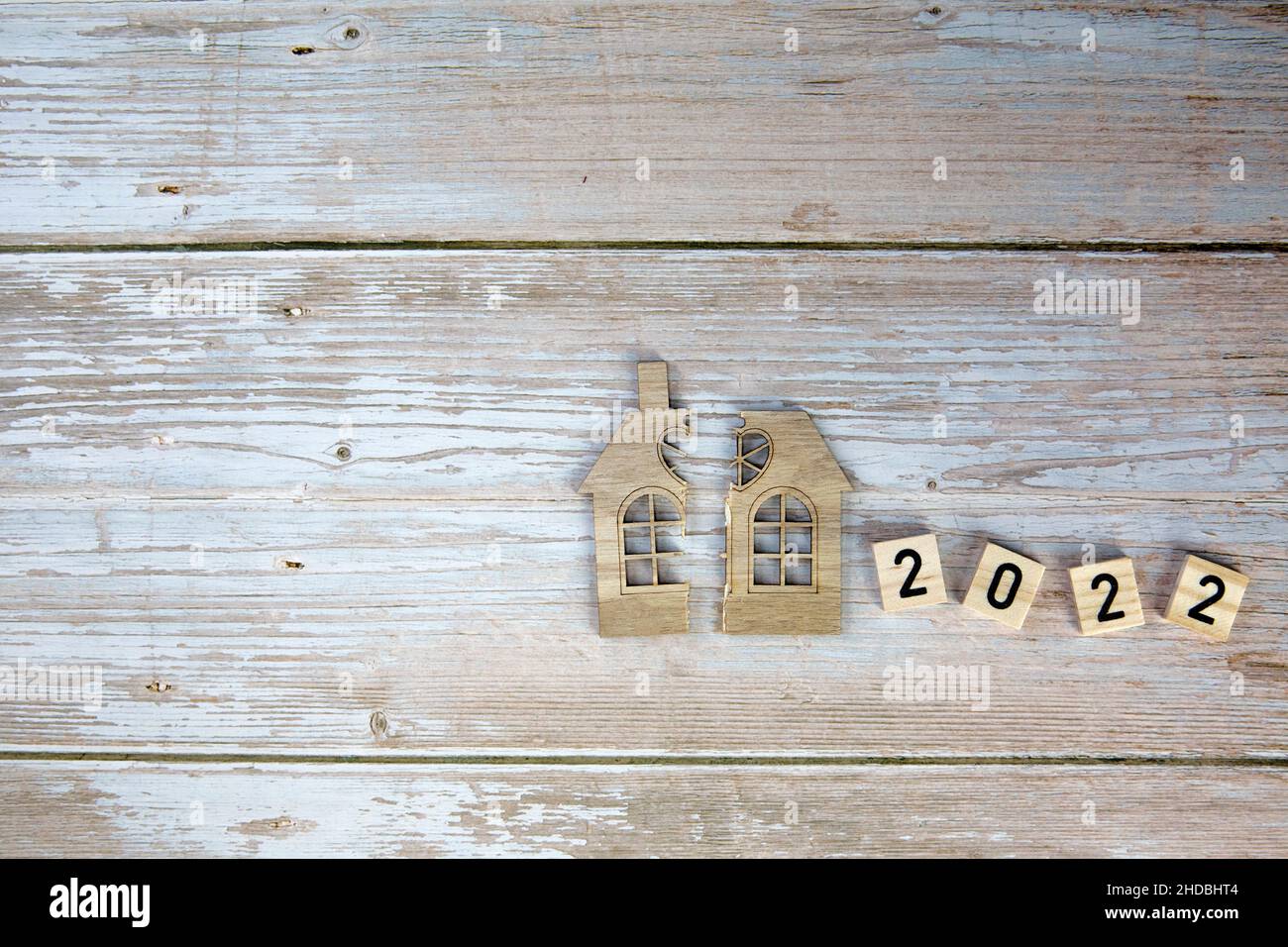 Scheidung, Teilung des Eigentums, Armut und kein Geld Konzept. Holz gebrochenes Haus und Neujahr 2022 Hintergrund. Hypothek, Miete, immobilienmakler Stockfoto