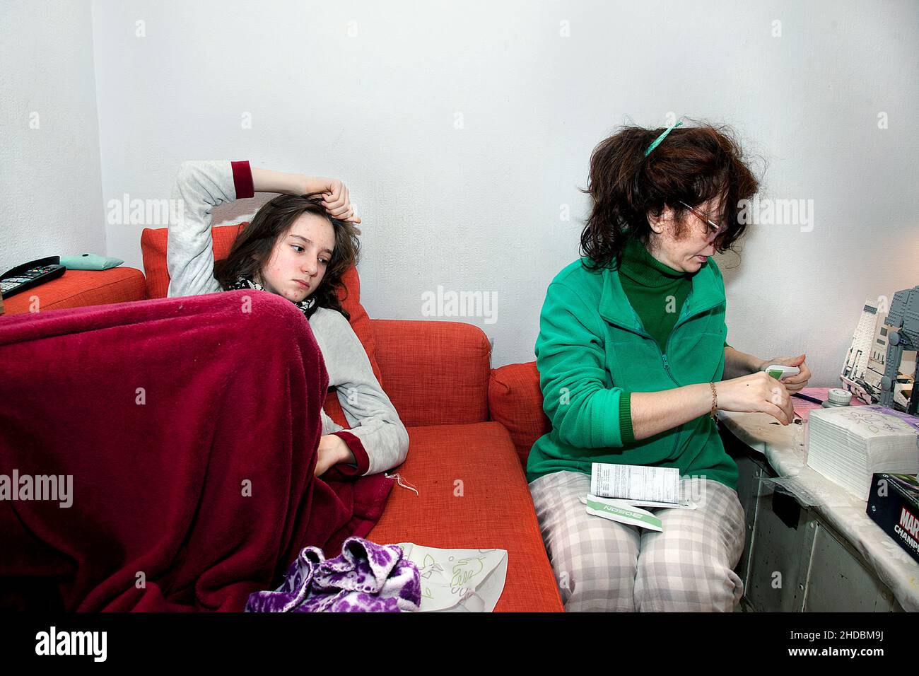 Die 50-jährige spanische Mutter bereitet zu Hause einen lateralen Durchflusstest für ihren Teenager-Sohn vor. Stockfoto