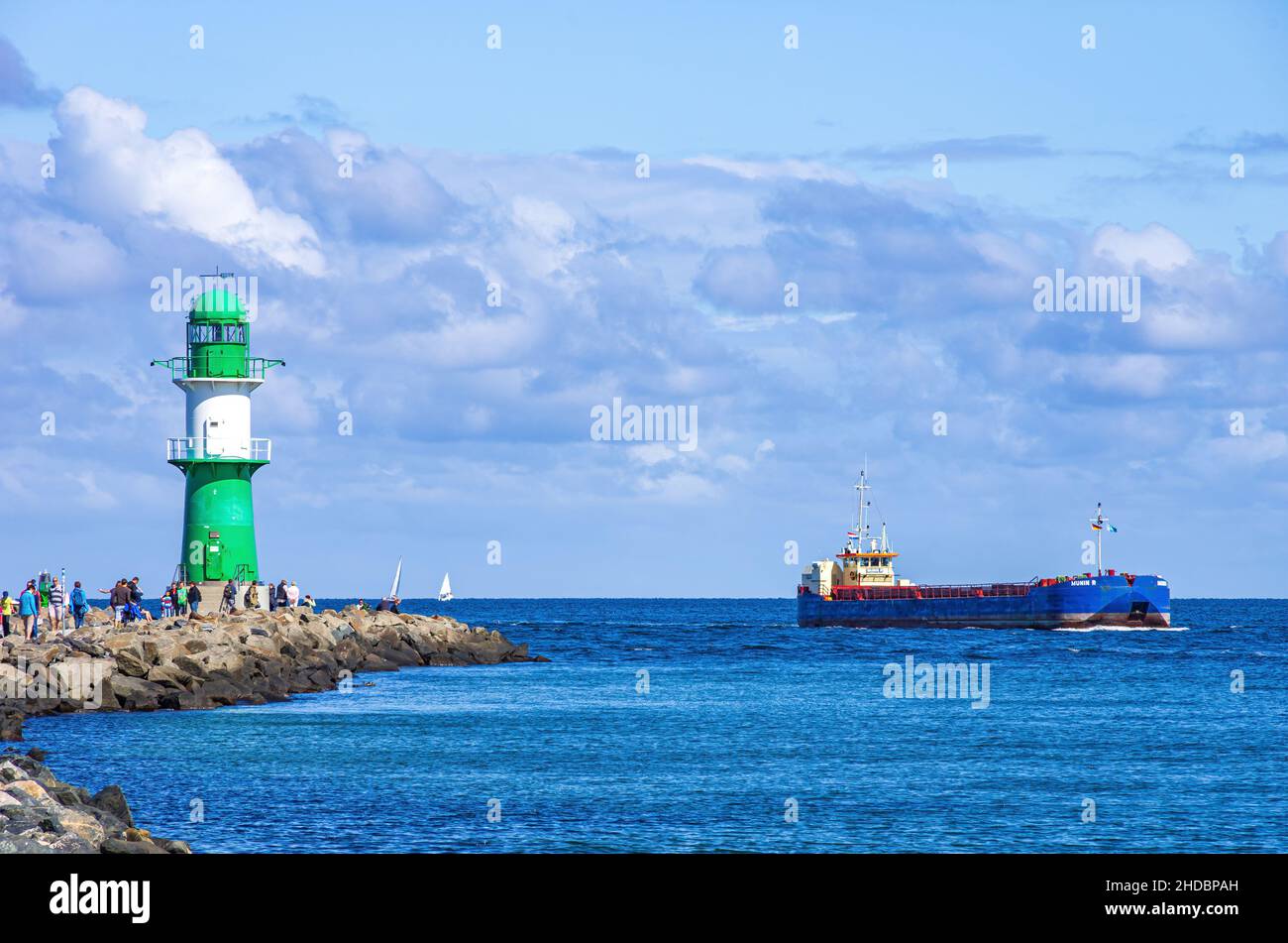 Rostock-Warnemünde, Mecklenburg-Vorpommern, Deutschland: Leuchtturm- und Seefahrerromantik auf der Westmole während des Frachtschiffs Munin R die Hafen Stockfoto