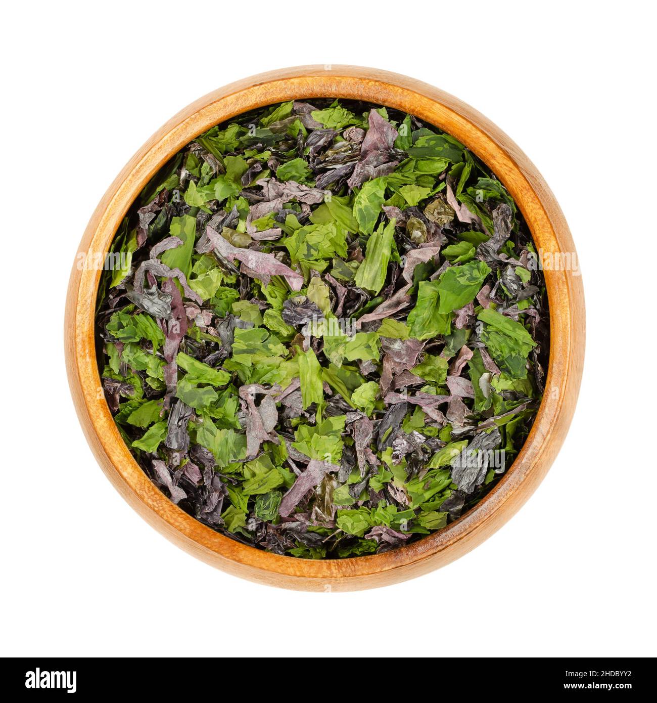 Seetang-Flocken in einer Holzschüssel. Mischung aus Dulse (Palmaria palmata), Meersalat (Ulva lactuca) und Nori. Getrocknete Meeresalgen, reich an natürlichem Jod. Stockfoto