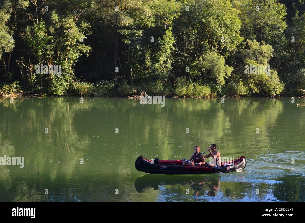 Mann und Frau im Kanu auf dem grünen Wasser der Isar, München, Bayern, Deutschland Stockfoto