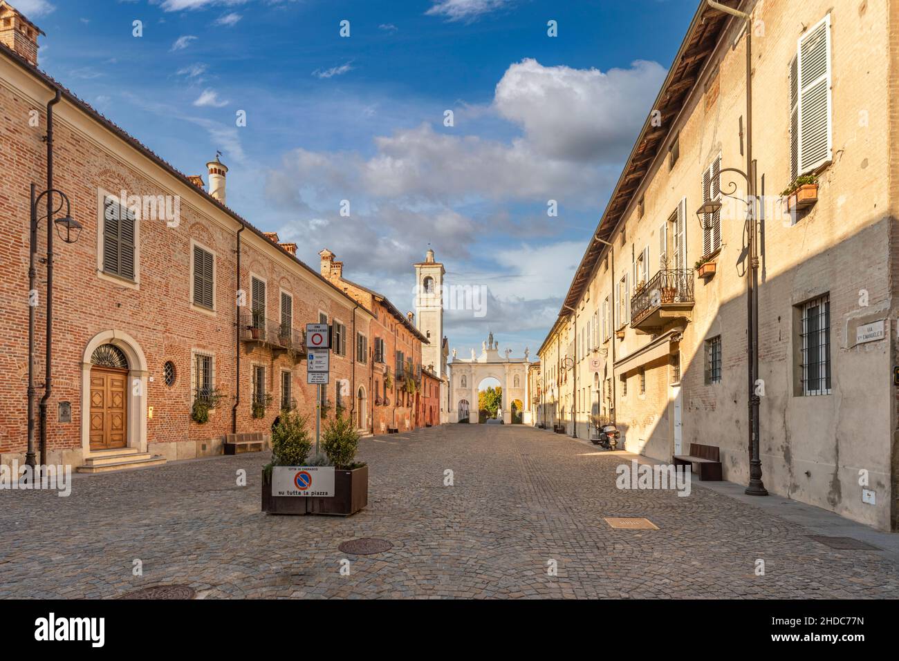 Cherasco, Cuneo, Italien - 27. Oktober 2021: Via Vittorio Emanuele II mit den historischen Gebäuden und dem Belvedere-Bogen im Hintergrund, Hauptstraße o Stockfoto