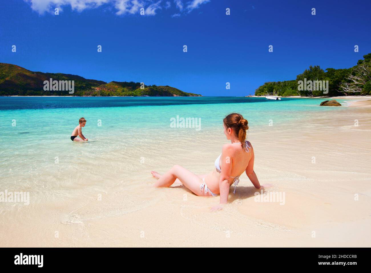 Frau liegt im Bikini am Strand, beobachtet ihre Jungen, Menschenleer, MR.: Ja, 30,35, 7, Jahre Stockfoto