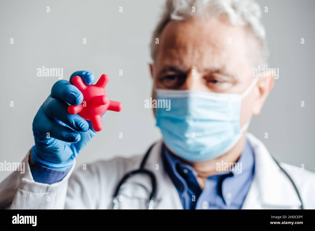 Arzt mit vereinfachtem SARS-CoV-2-Virusmodell Stockfoto