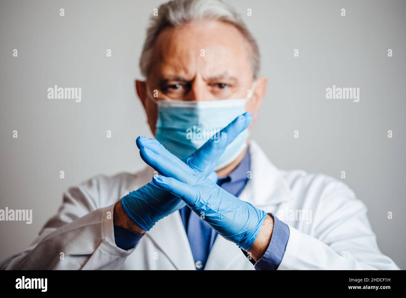 Medizinische Fachkraft, die einem Patienten sagt, dass er die soziale Distanzierung respektieren soll Stockfoto