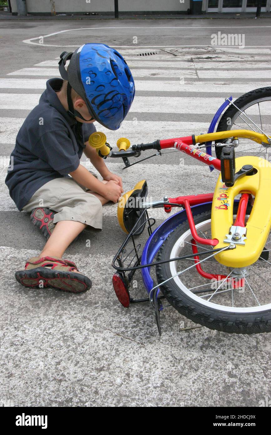 Kleiner Junge, 5 Jahre, stürzt mit dem Fahrrad, Verkehrsunfall, Unfall, Fahrradhelm, Stockfoto