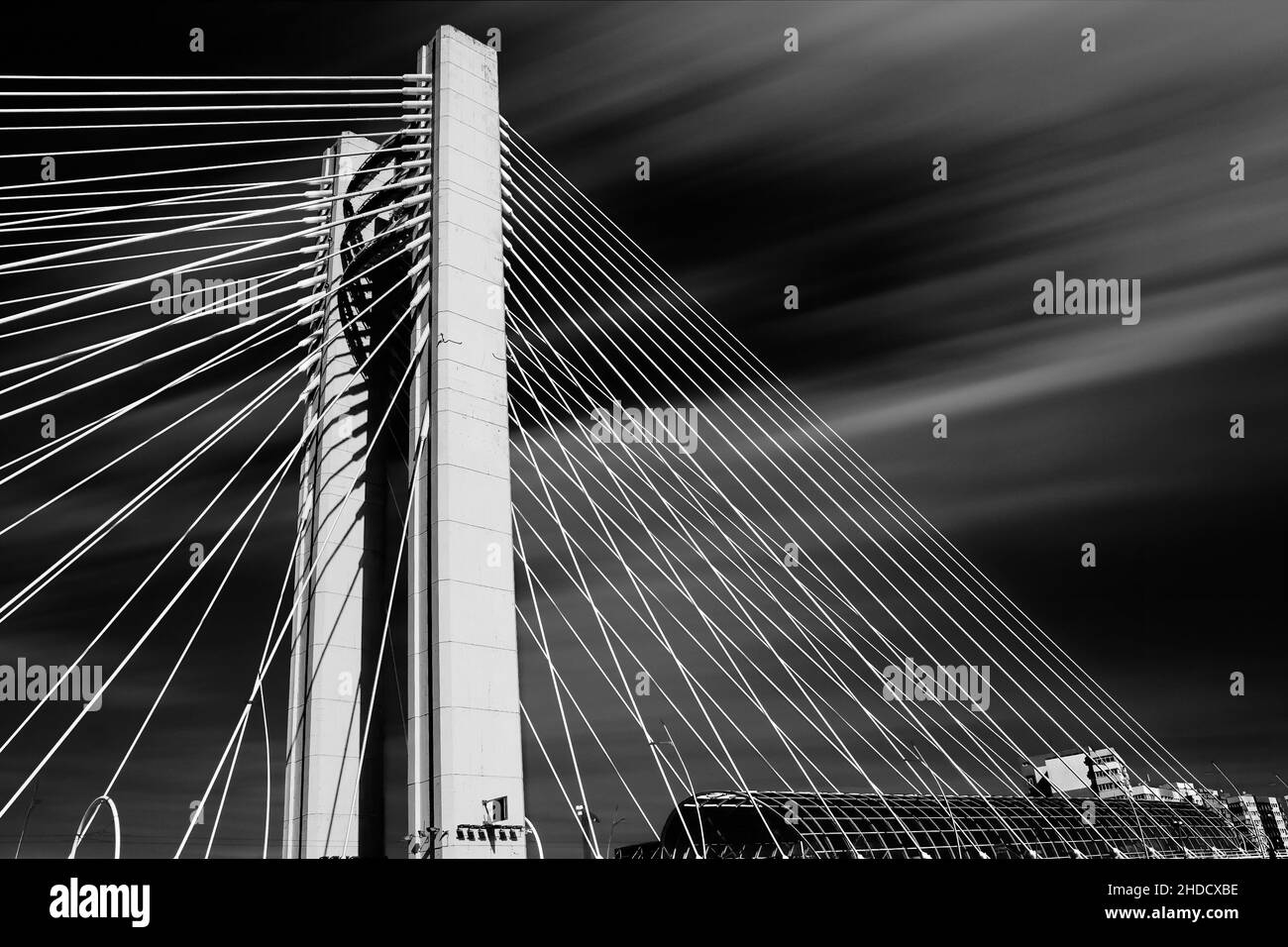 Schöne Aussicht auf eine freischwinger Brücke mit vielen Seilen in einem verschwommenen bewölkten Hintergrund Stockfoto