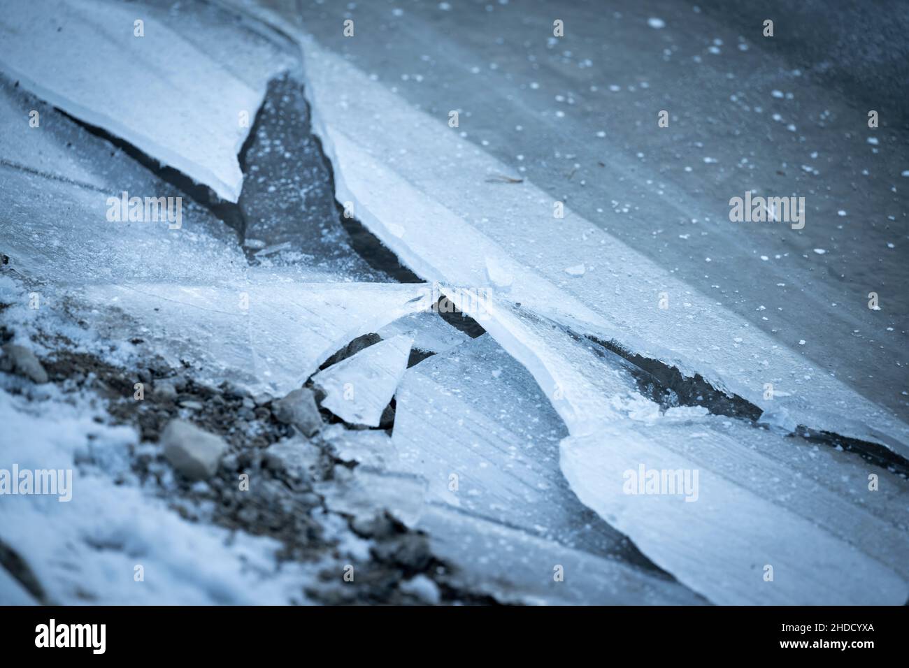 Gebrochene Eisschare an einem eisigen Wintertag am Ufer eines Steinstrandes Stockfoto