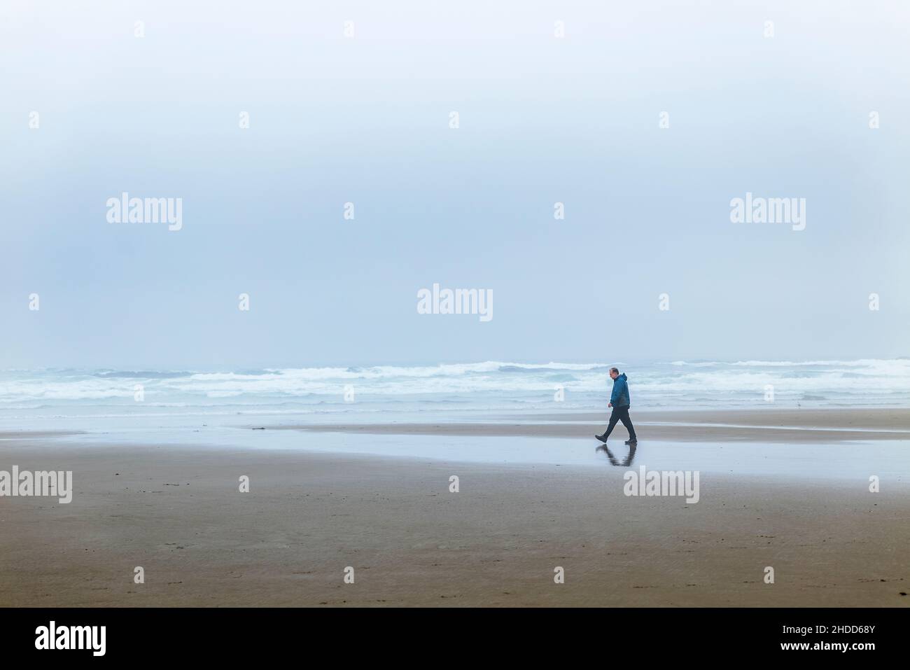 Ein Mann, der auf dem Foggy Beach, dem Pazifik, Newport, Oregon und den USA spazierenging Stockfoto