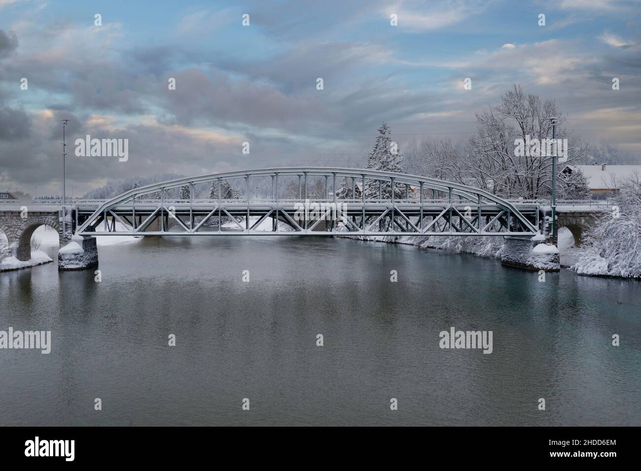 Bogenbrücke in Stahlkonstruktion mit Traversen für die Eisenbahn im Winter mit wolkenblauem Himmel Stockfoto