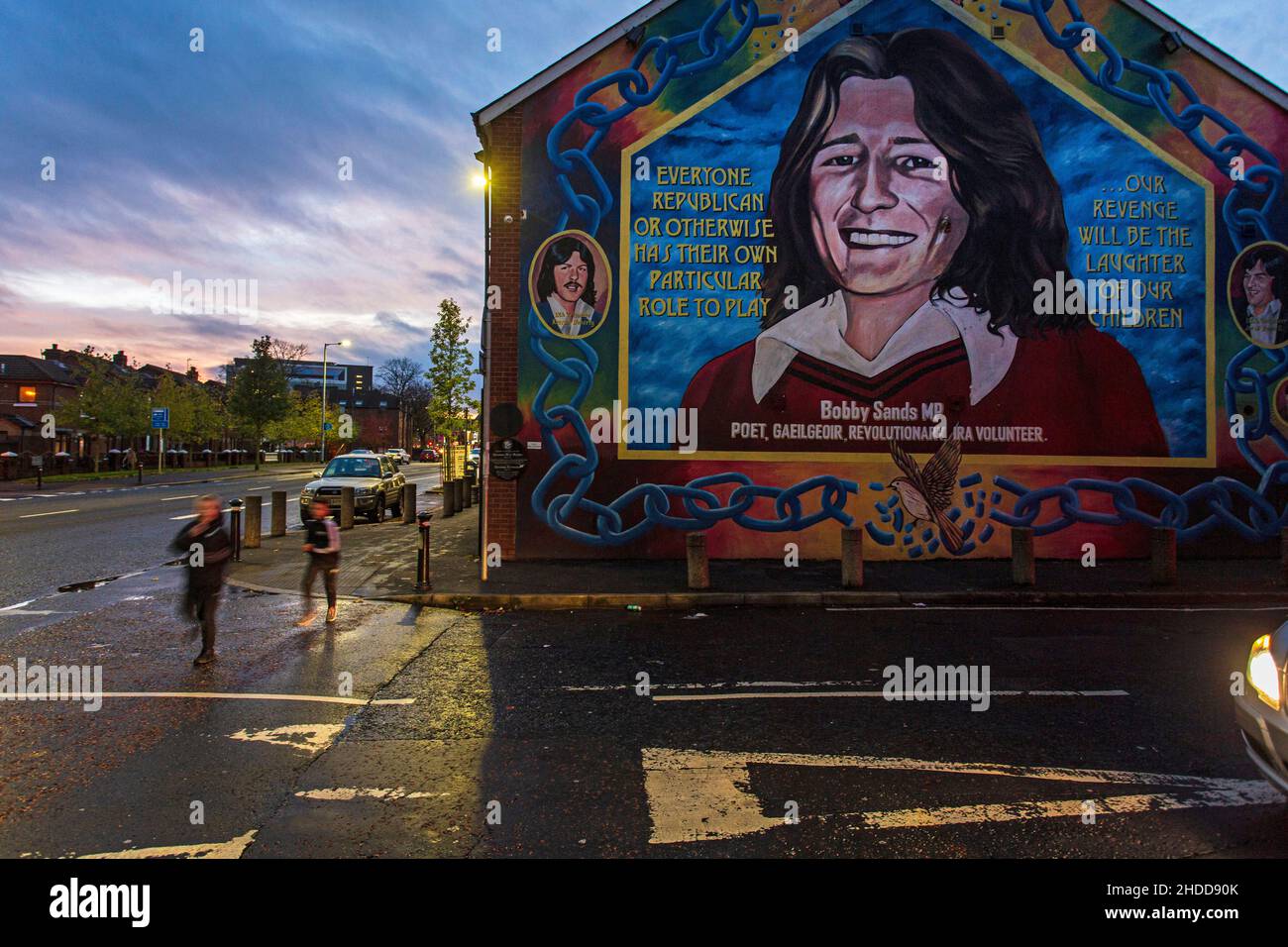 Kinder, die das Wandbild von Bobby Sands in Belfast, Nordirland, passieren, er ist das Symbol des Krieges zwischen katholiken und Protestanten Stockfoto