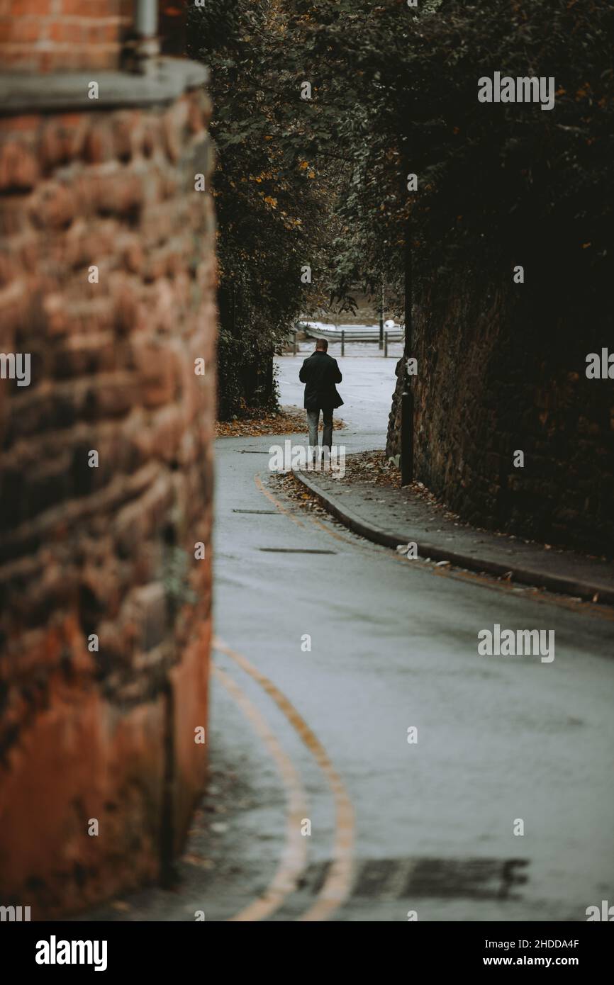 Vertikale Aufnahme einer Person, die in einer steilen Gasse läuft Stockfoto