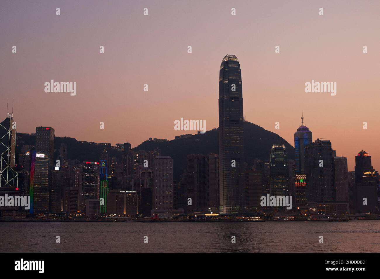 Hongkong bei Sonnenuntergang, von der anderen Seite des Victoria Harbour aus gesehen, während die Dämmerung in die Stadt einbricht. Stockfoto