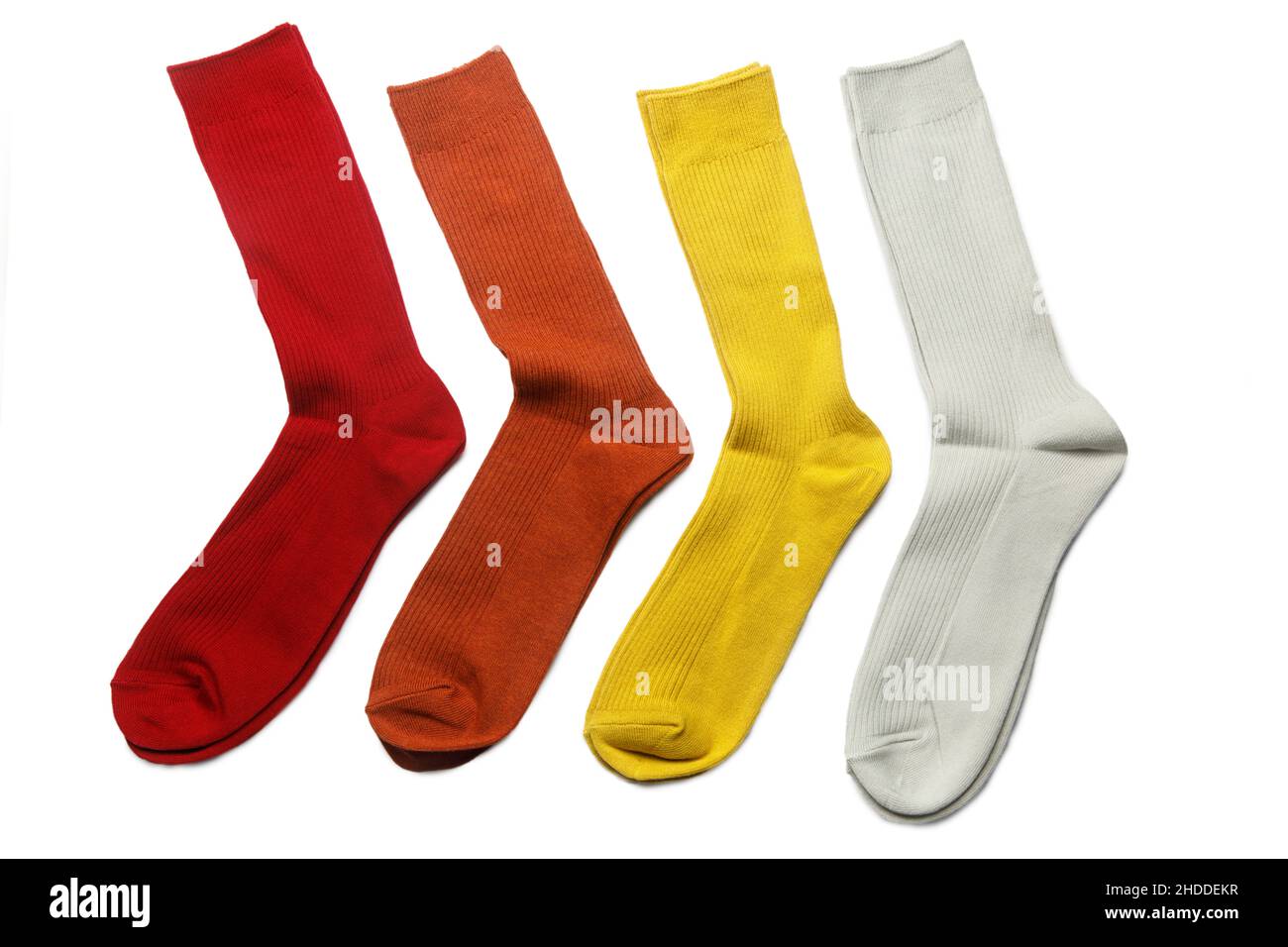 Vier Paar mehrfarbige Socken: Gelb, orange, grau, rot auf weißem Hintergrund Stockfoto