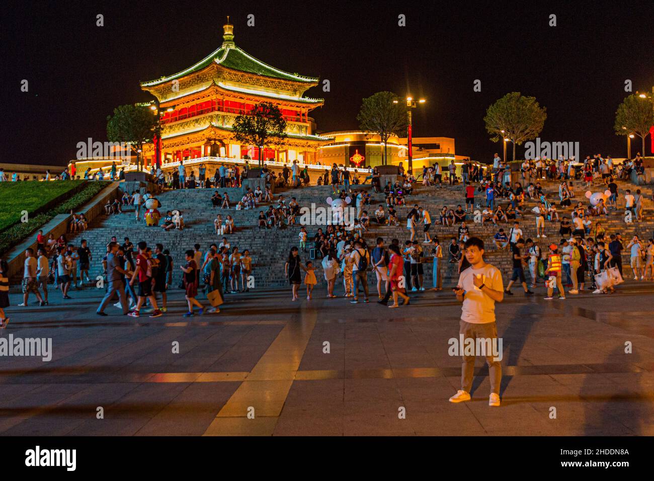 XI'AN, CHINA - 2. AUGUST 2018: Abendansicht von Menschen, die auf Stufen in der Nähe des Glockenturms in Xi'an, China, sitzen Stockfoto