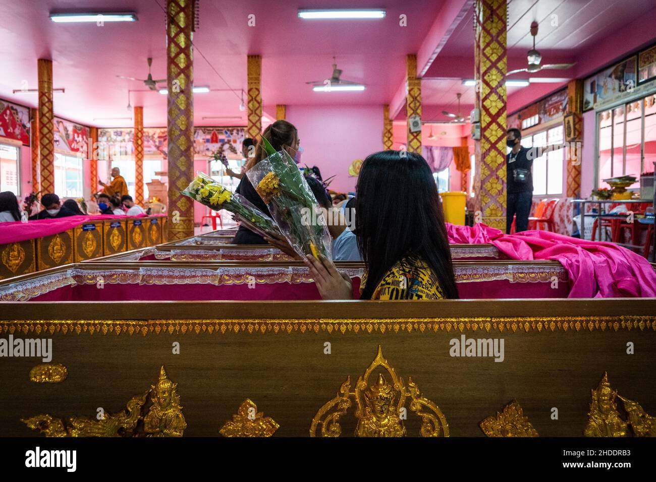 Bangkok, Thailand. 31st Dez 2021. Eine Thailänderin sitzt in einem Sarg auf, nachdem sie ein spirituelles Ritual im Tempel beendet hat.Devotees werden in einem jährlichen Neujahrsritual im Wat Takien in der Nähe von Nonthaburi wiederbelebt. Dieser Ritus beginnt mit einem Gebet, gefolgt von den Teilnehmern, die mit heiligen Fäden um ihren Kopf gewickelt singen, bevor sie sich in einen Sarg legen, um zu „sterben“ und gereinigt zu werden. Kredit: SOPA Images Limited/Alamy Live Nachrichten Stockfoto