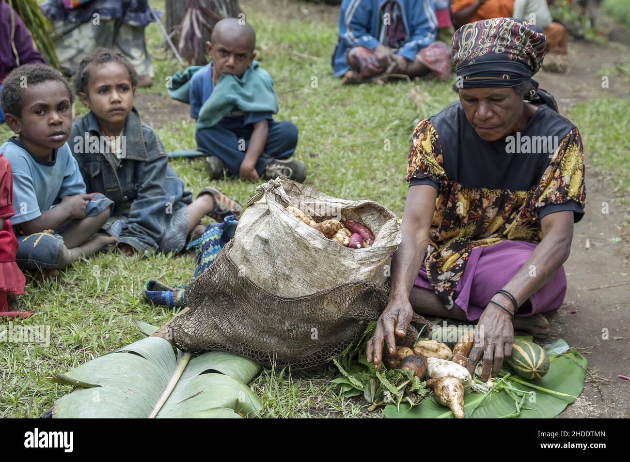Papua-Neuguinea; Östliches Hochland; Goroka Namta; Papua-Frau verbreitet typisches Gemüse auf Bananenblättern. Papua Frau legt Gemüse auf ein Bananenblatt Stockfoto