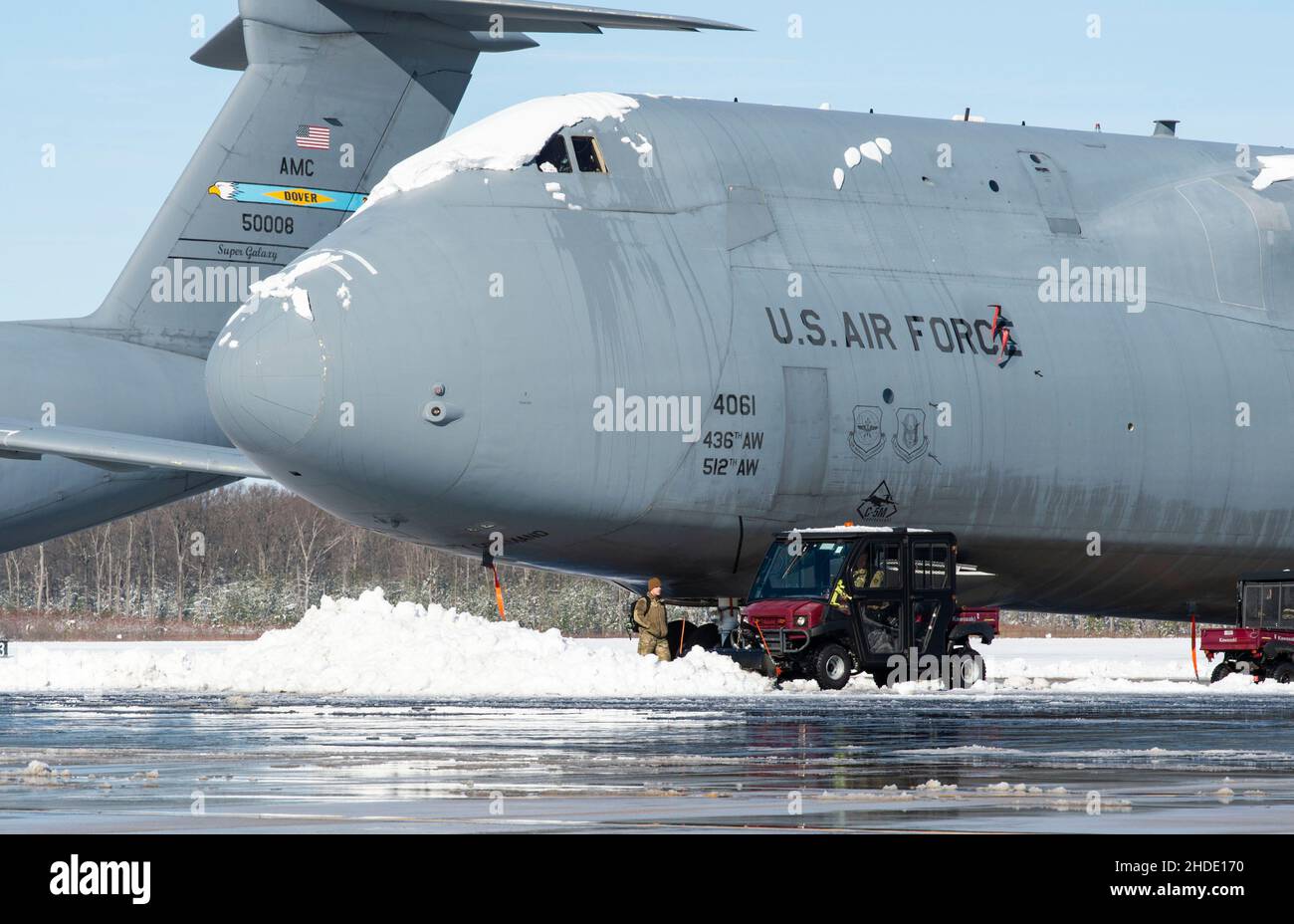 Die Betreuer des Teams Dover entfernen Schnee von einer C-5M Super Galaxy auf der Dover Air Force Base, Delaware, 4. Januar 2022. Nachdem der Wintersturm Frida acht Zentimeter Schnee fallen ließ, arbeitete das Basispersonal fleißig daran, den normalen Betrieb wieder aufzunehmen. (USA Luftwaffe Foto von Roland Balik) Stockfoto