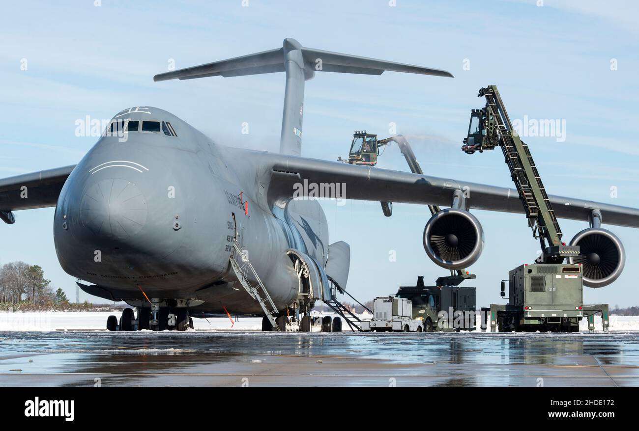 Die Flugzeugbetreuer des Teams Dover entfernen Schnee und Eis aus einer C-5M Super Galaxy auf der Fluglinie auf der Dover Air Force Base, Delaware, 4. Januar 2022. Nachdem der Wintersturm Frida acht Zentimeter Schnee fallen ließ, arbeitete das Basispersonal fleißig daran, den normalen Betrieb wieder aufzunehmen. (USA Luftwaffe Foto von Roland Balik) Stockfoto