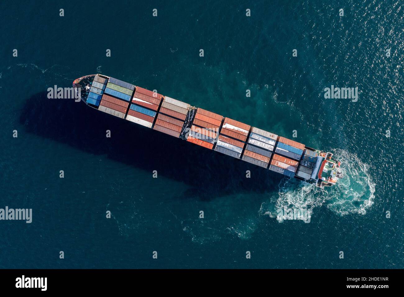 Das Seecontainerschiff bewegt sich auf See. Um den Schaum von der Arbeit der Schraube. Blick auf das Schiff von oben. Stockfoto
