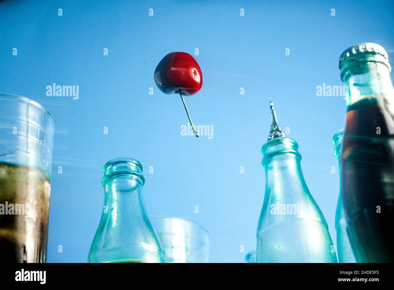 Kirsche schwebt wie ein Luftballon, umgeben von Cola-Flaschen, in Paris Frankreich durch die Luft Stockfoto