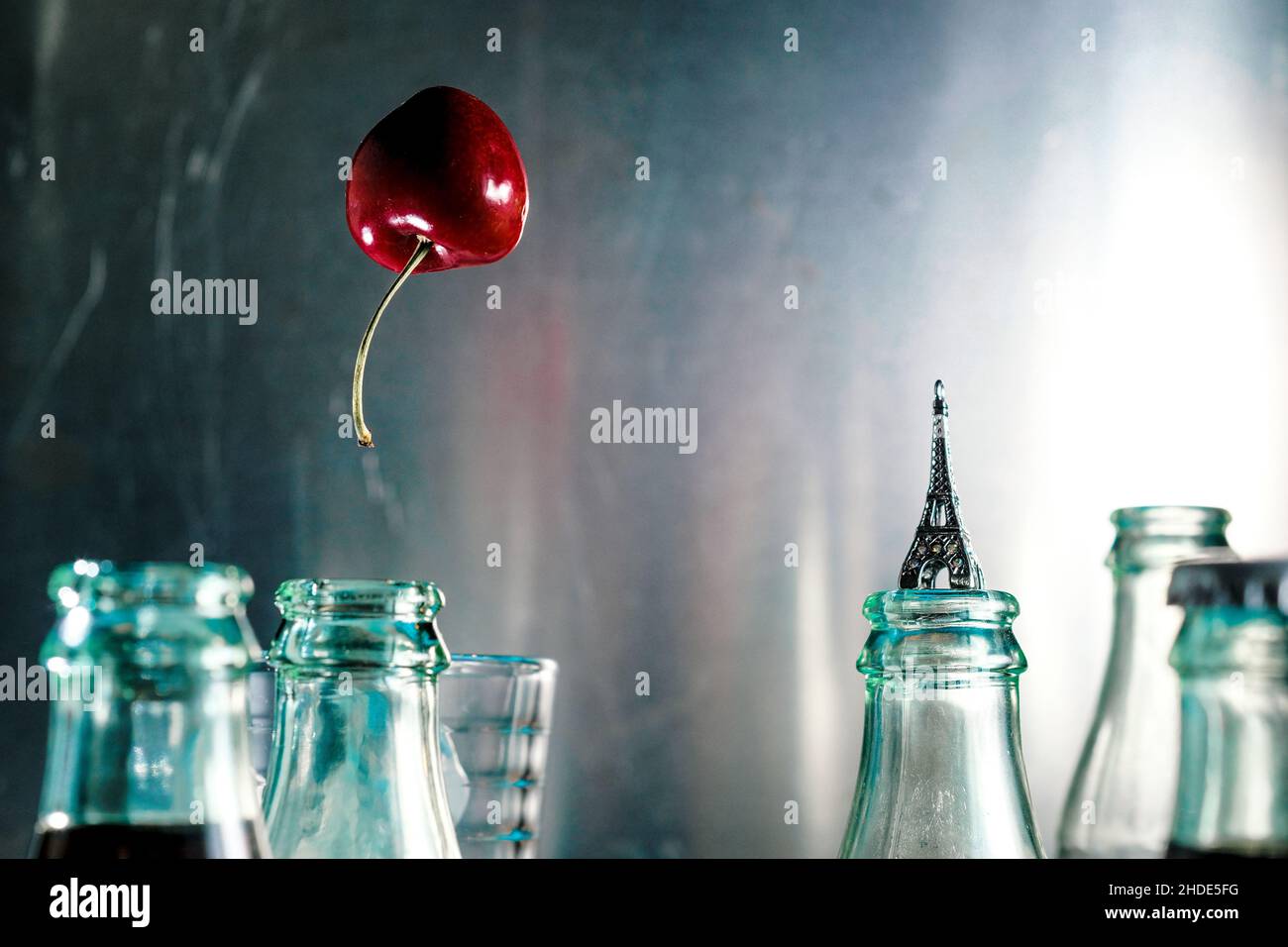 Kirsche schwebt wie ein Luftballon, umgeben von Cola-Flaschen, in Paris Frankreich durch die Luft Stockfoto