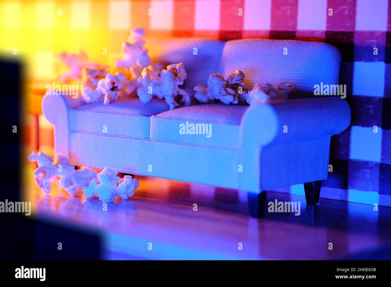 Film- und Chill-Konzept mit Popcorn auf der Miniatur-Couch und Fernsehen Stockfoto