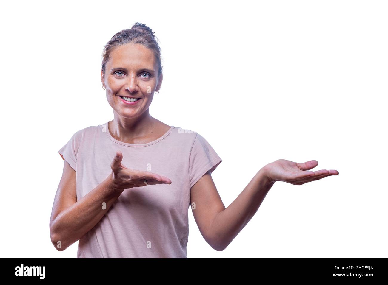 Eine lächelnde Frau mit den Handflächen nach oben, die etwas zeigt Stockfoto