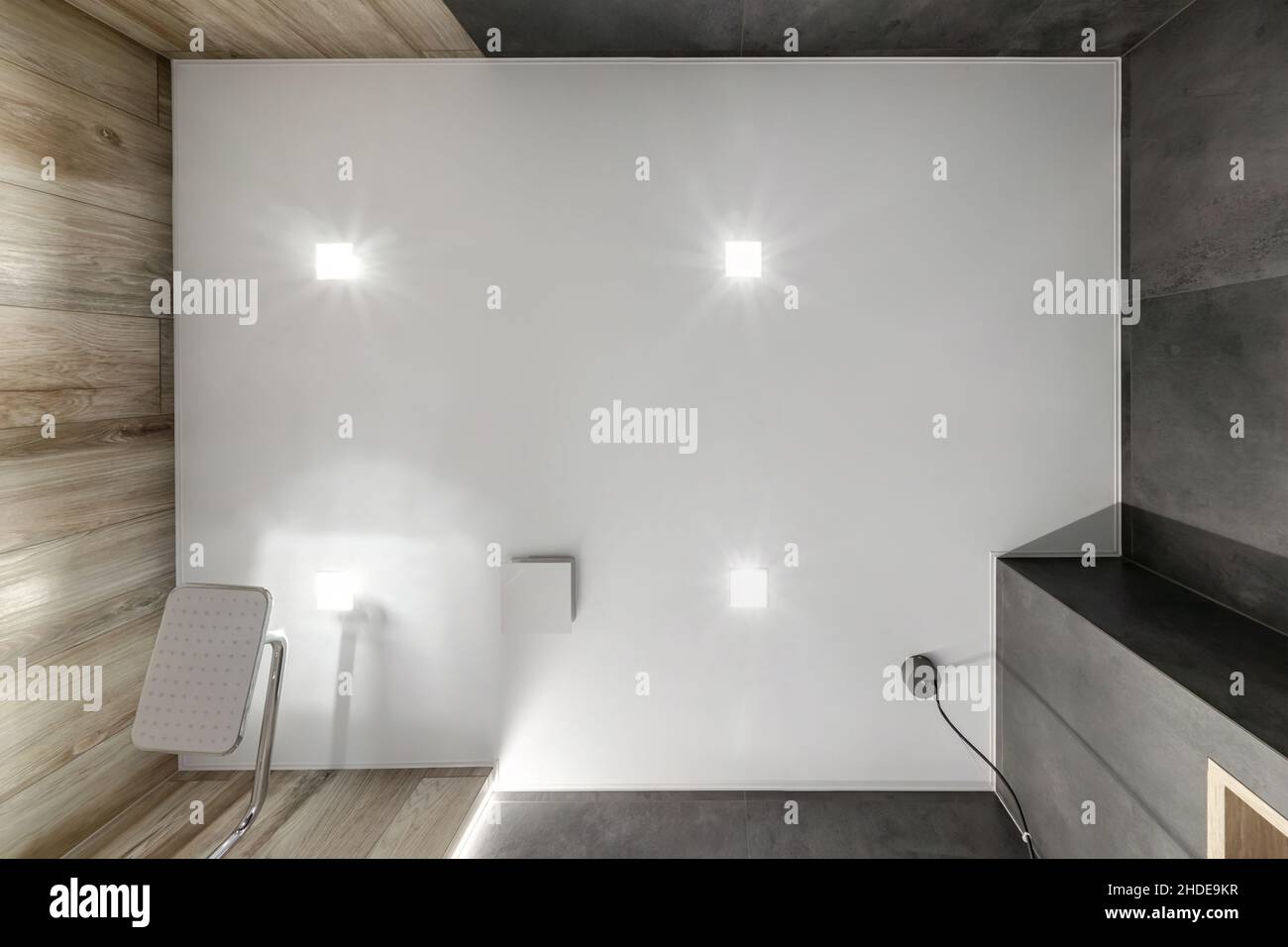 Abgehängte oder dehnbare Decke mit Halogenstrahlern und Trockenbau in leerem Raum in Wohnung oder Haus Stockfoto