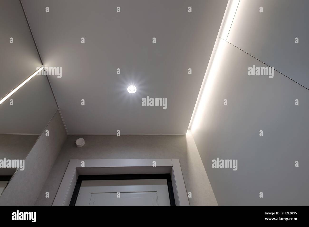 Abgehängte oder dehnbare Decke mit Halogenstrahlern und Trockenbau in leerem Raum in Wohnung oder Haus Stockfoto