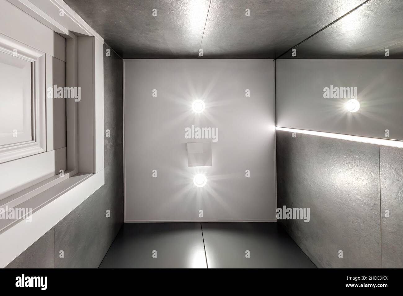 Abgehängte oder dehnbare Decke mit Halogenstrahlern und Trockenbau in leerem Raum in Wohnung oder Haus Stockfoto