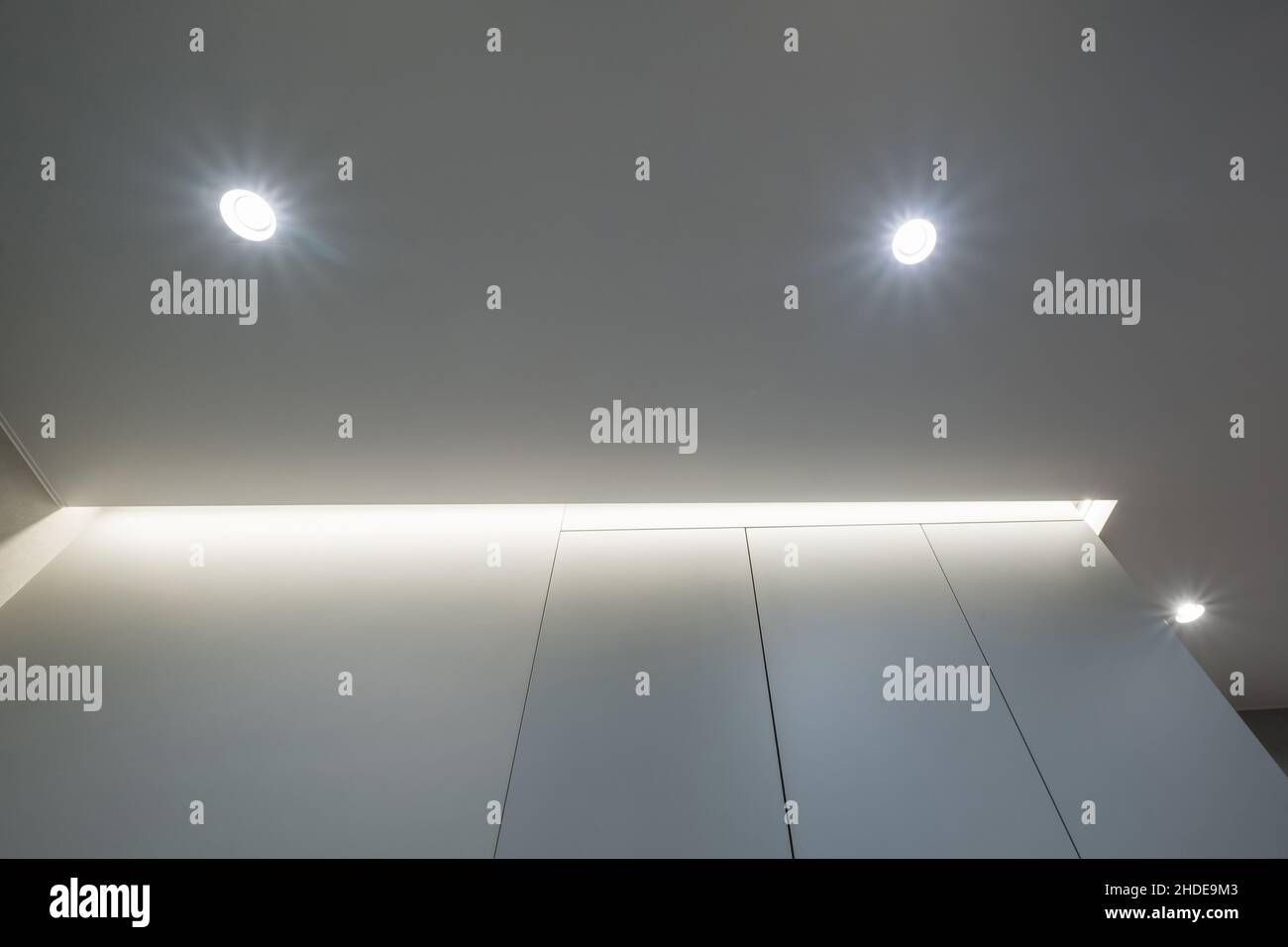 Abgehängte oder dehnbare Decke mit Halogenstrahlern und Trockenbau in leerem Raum in Wohnung oder Haus Stockfoto