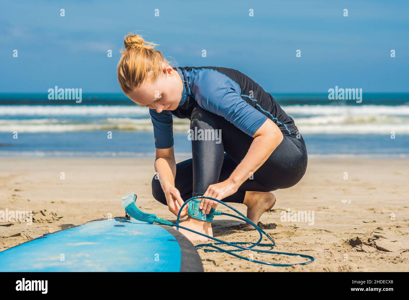 Konzept für Sommerzeit und aktive Erholung. Die junge Surferin, eine Anfängerin, nimmt die Leine über die Beine, geht auf großen barral-Wellen auf dem Ozean surfen, dressed in Stockfoto