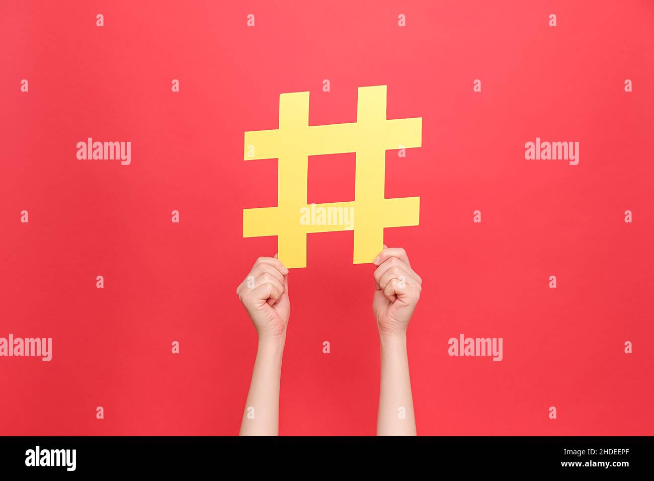 Nahaufnahme von weiblichen Händen mit großem gelben Papier-Hashtag-Symbol, Hash-Zeichen von berühmten Medieninhalten, Social-Media-Marketing und Blog-Promotion, isol Stockfoto