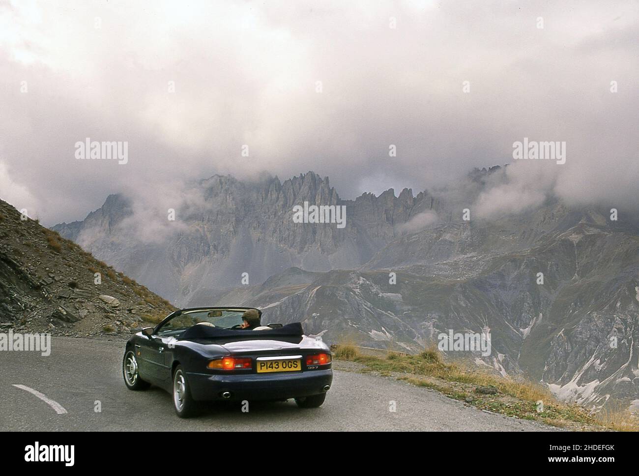 Roadtrip entlang der Route des Grandes Alpes, Autofahren auf dem Col Du Galibier France in einem 1996 Aston Martin DB7 Volante. Stockfoto
