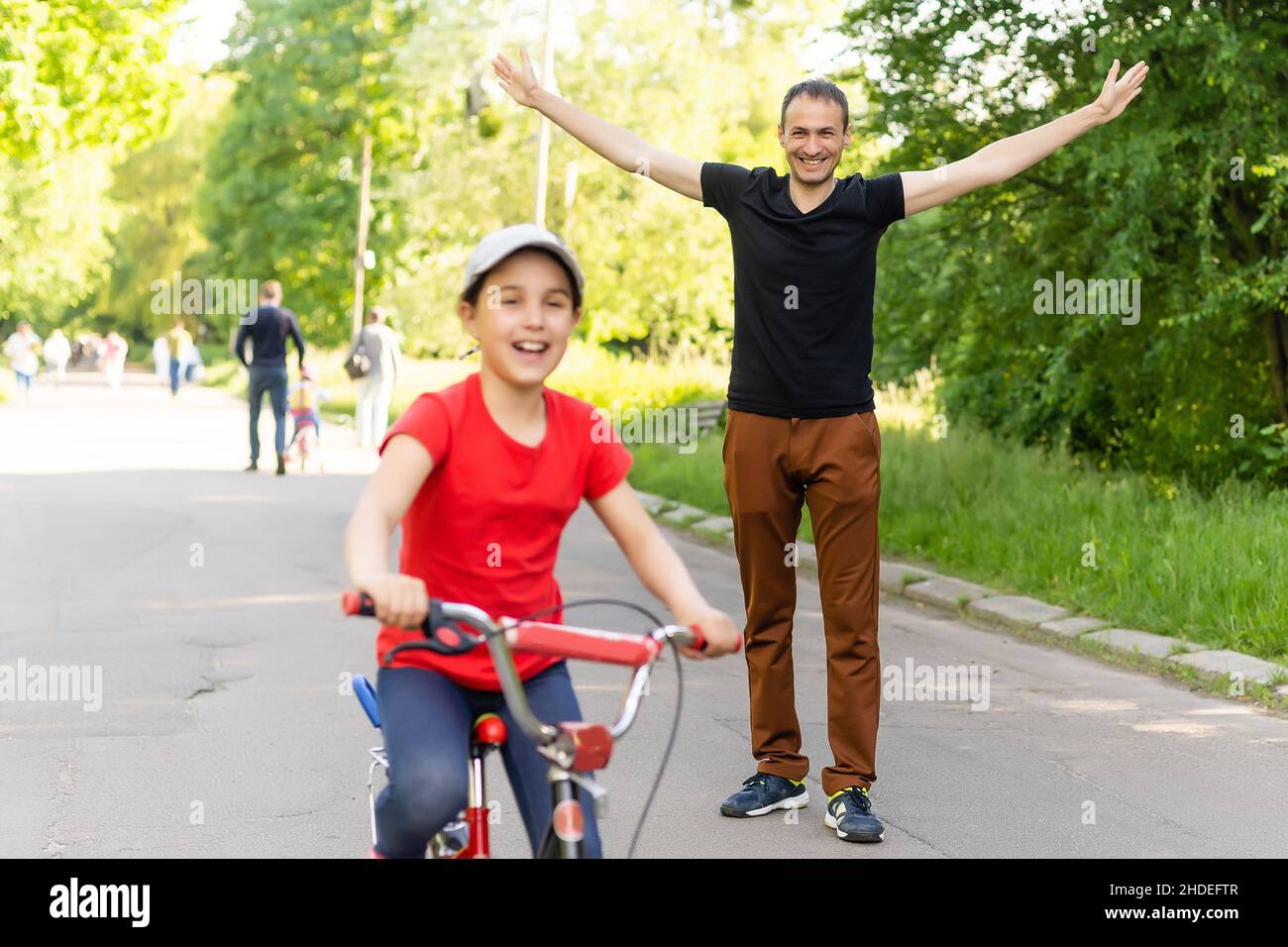 Glückliche Familie Vater lehrt Kind Tochter, ein Fahrrad im Park in der Natur zu fahren Stockfoto