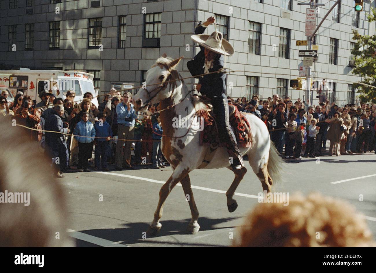 Ein Cowboy zu Pferd in mexikanischem Outfit schwingt sein Lasso während der Columbus Day Parade in den frühen achtziger Jahren in New York, USA Stockfoto