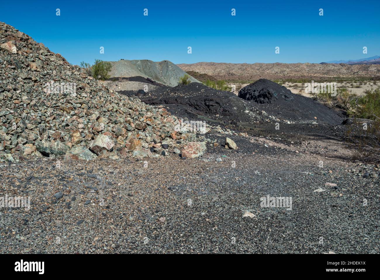 Abfallgestein (grau), Schlacke (schwarz) in der Nähe der Kupferschmelze in Swansea Copper Mining Townsite, Buckskin Mountains, Sonoran Desert, Arizona, USA Stockfoto
