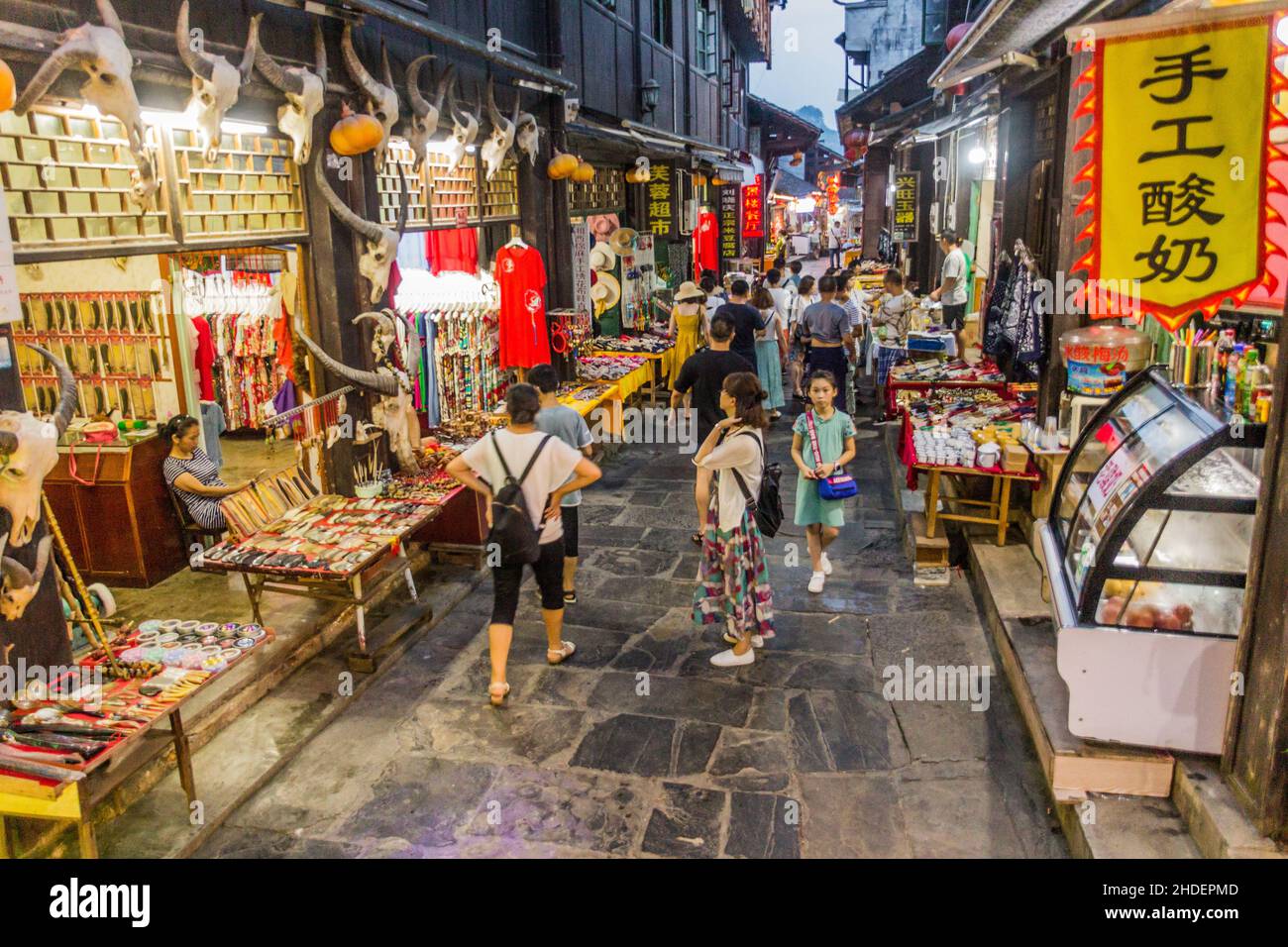 FURONG ZHEN, CHINA - 11. AUGUST 2018: Abendansicht einer engen Gasse mit verschiedenen Ständen in der Stadt Furong Zhen, Provinz Hunan, China Stockfoto