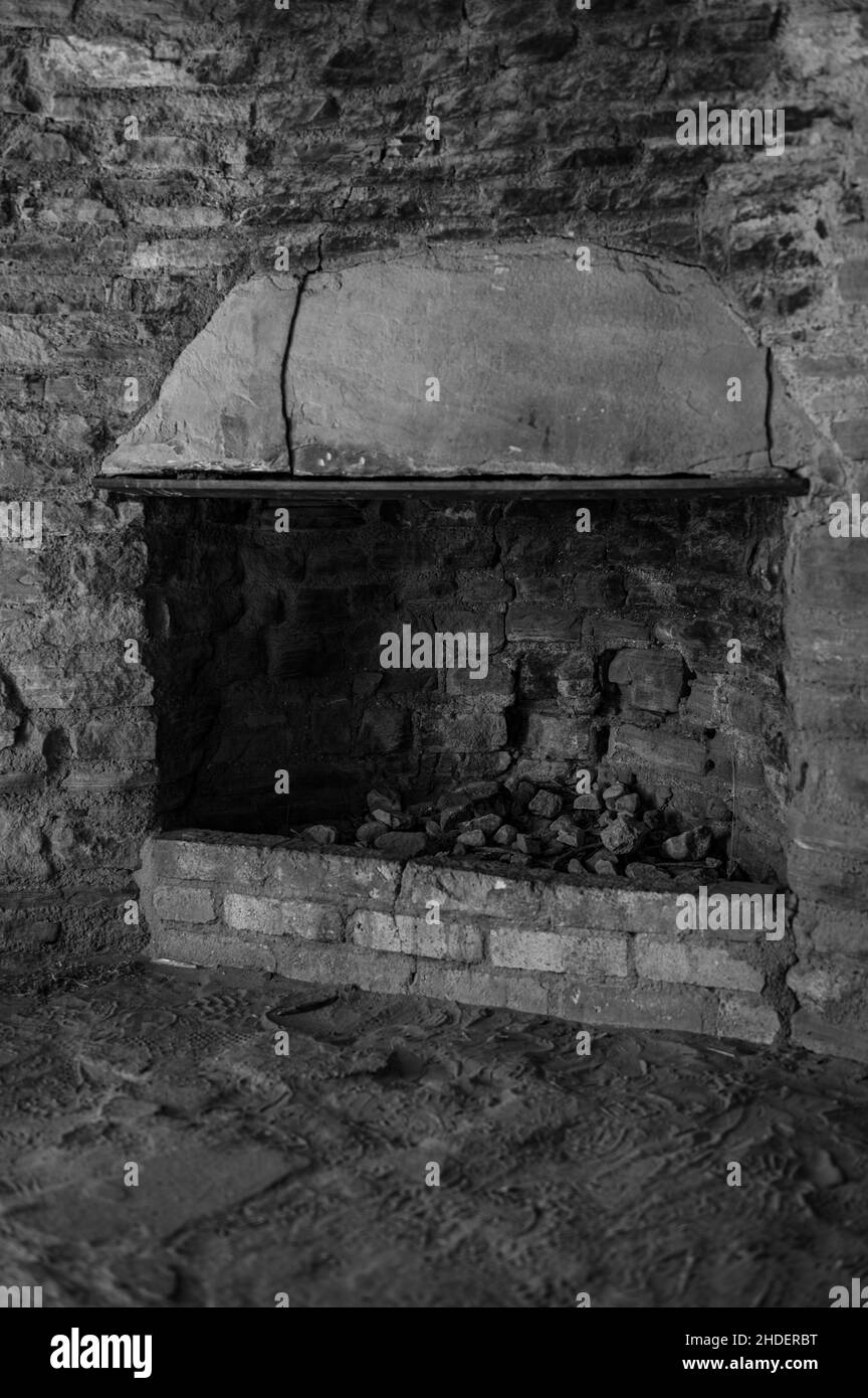 Alter Kamin mit verfallenen Wänden in Schwarz und Weiß Stockfoto