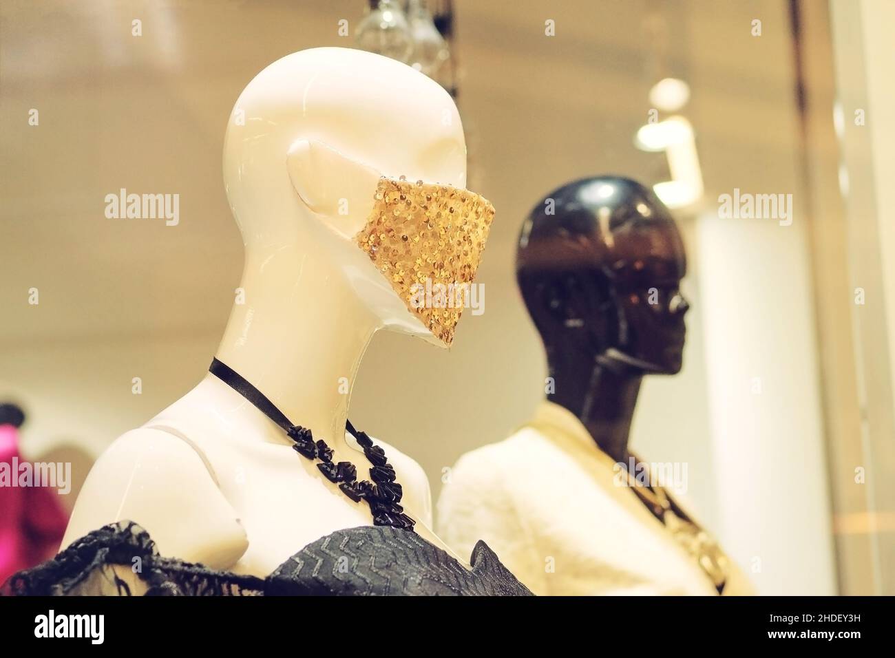 Schaufensterpuppe mit Mode Gesichtsmaske gegen covid 19 stehen in einem Bekleidungsgeschäft. Mannequins in der großen Mall. Stockfoto