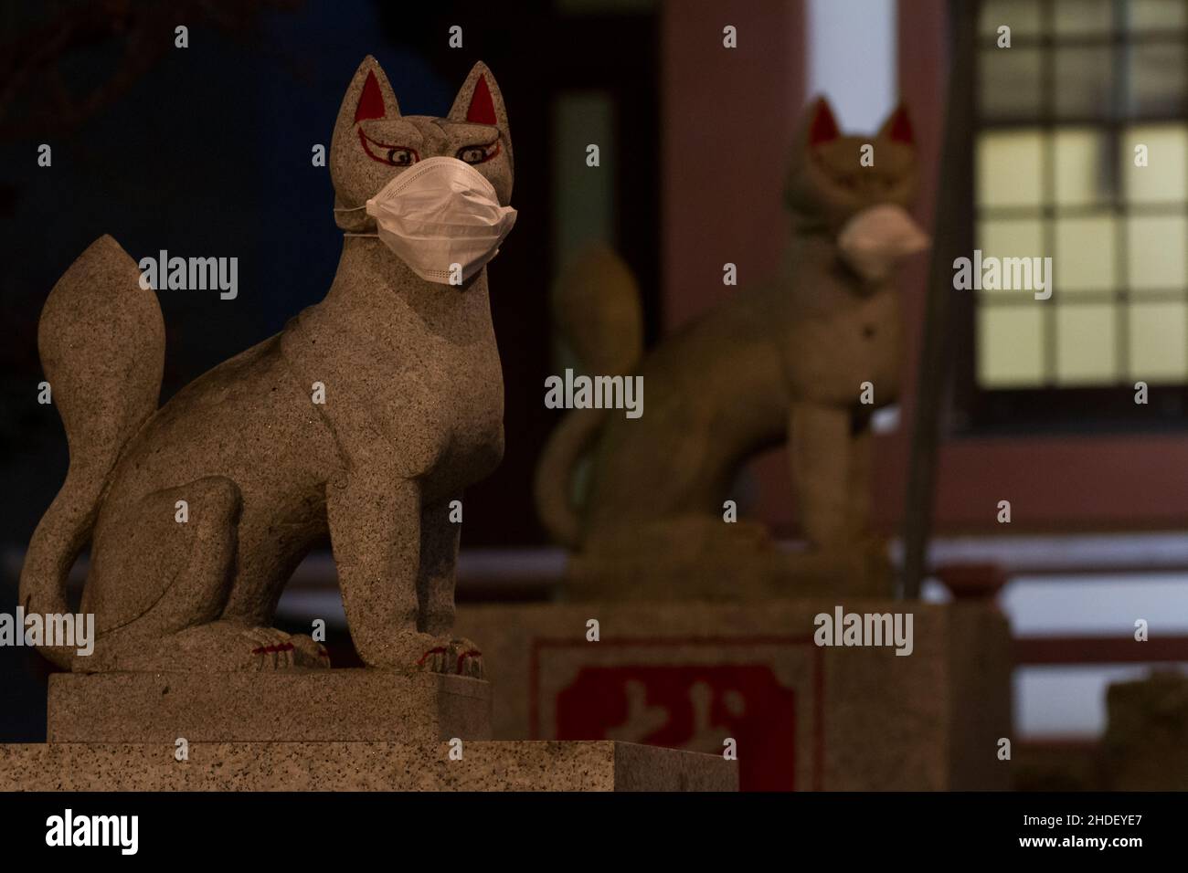 Inari-Füchse oder kitsune Statuen mit Gesichtsmasken am Sakuramoriinari-Schrein in Sagami-Otsuka, Kanagawa, Japan. Stockfoto