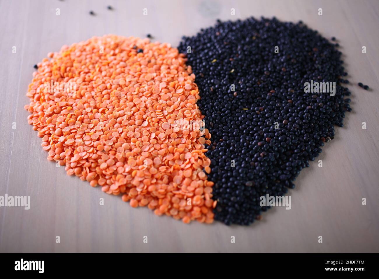 Rote und schwarze Linsen bilden eine valentine-Herzform für ein gesundes Leben Stockfoto