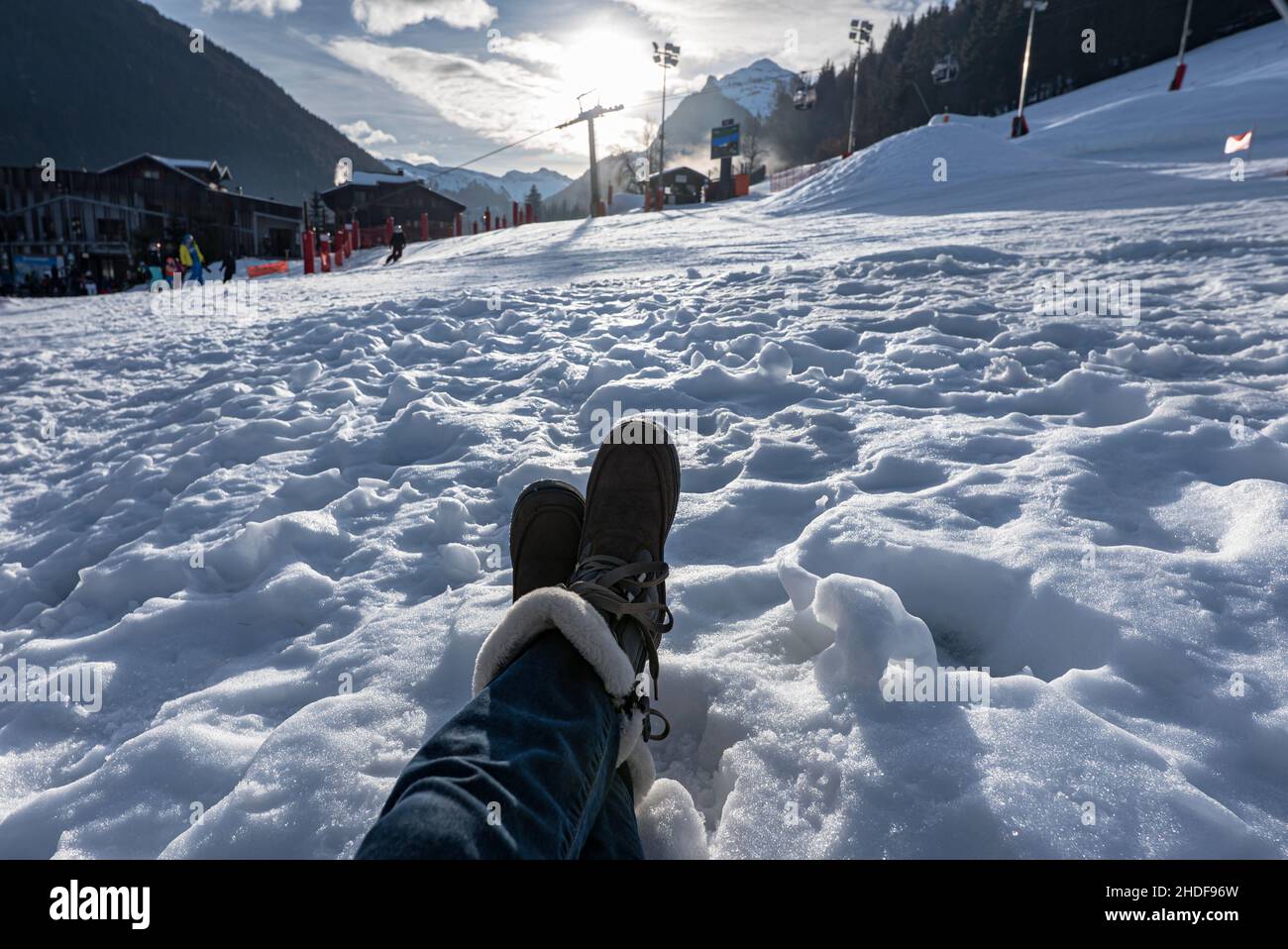 Damen Füße im Schnee tragen nach den Skischuhen mit den Skipisten und Sessellift auf dem Hintergrund in der französisch Morzine Skigebiet. Stockfoto